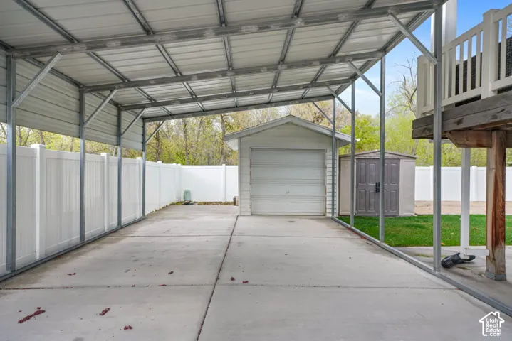 Covered concrete driveway with metal carport