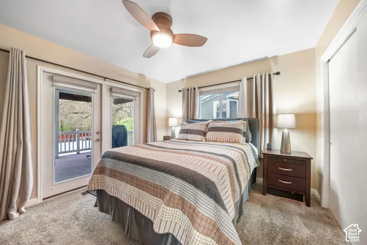 Master Bedroom with Sliding glass doors opening to the back deck, soft carpeting, a ceiling fan with integrated lighting, and a window with blinds