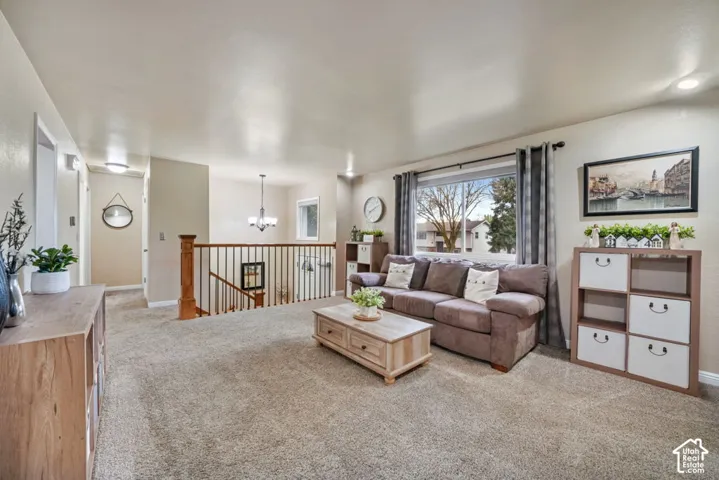 Carpeted living area with a large window, recessed lighting, and a wood banister