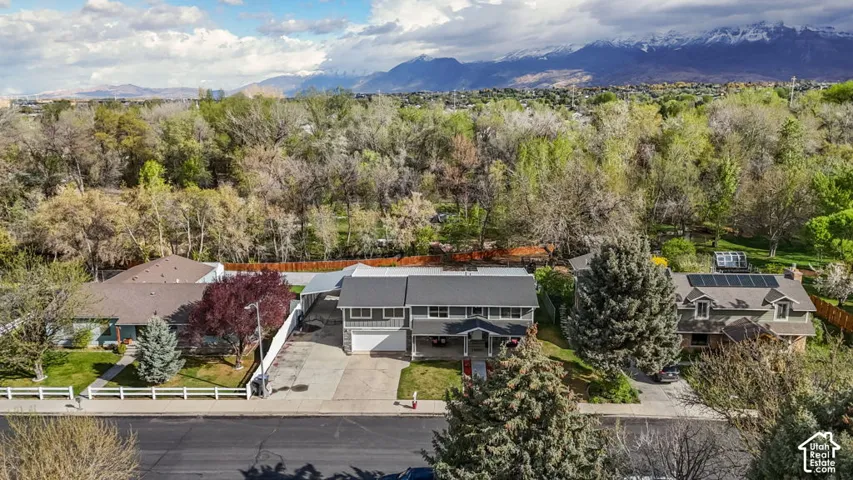 Gray two-story residence with an attached garage and front yard