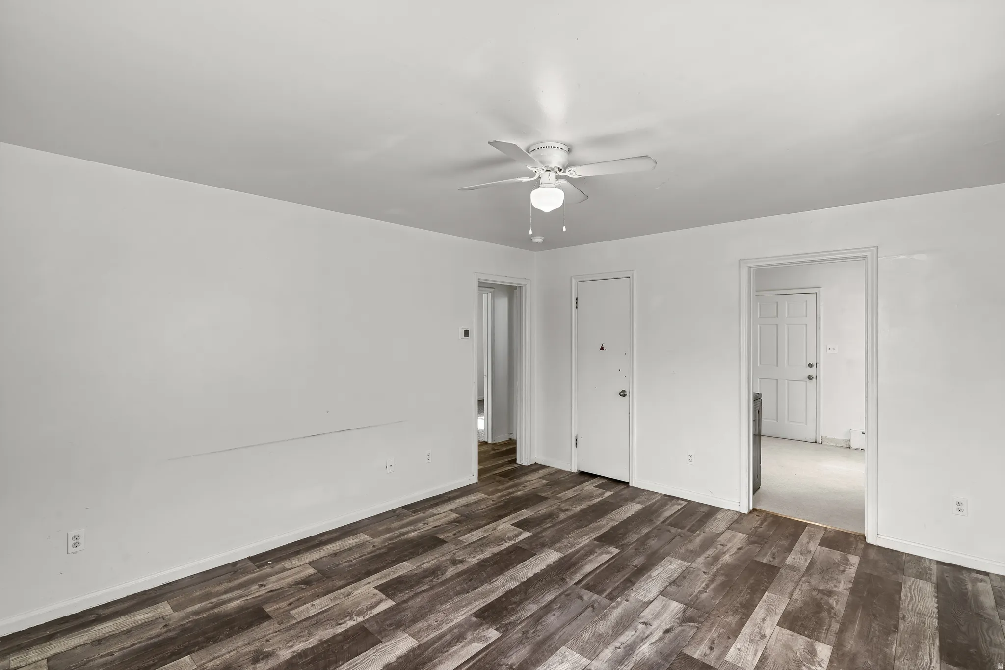 Wood-finish flooring with a neutral color palette, featuring a ceiling fan with integrated lighting