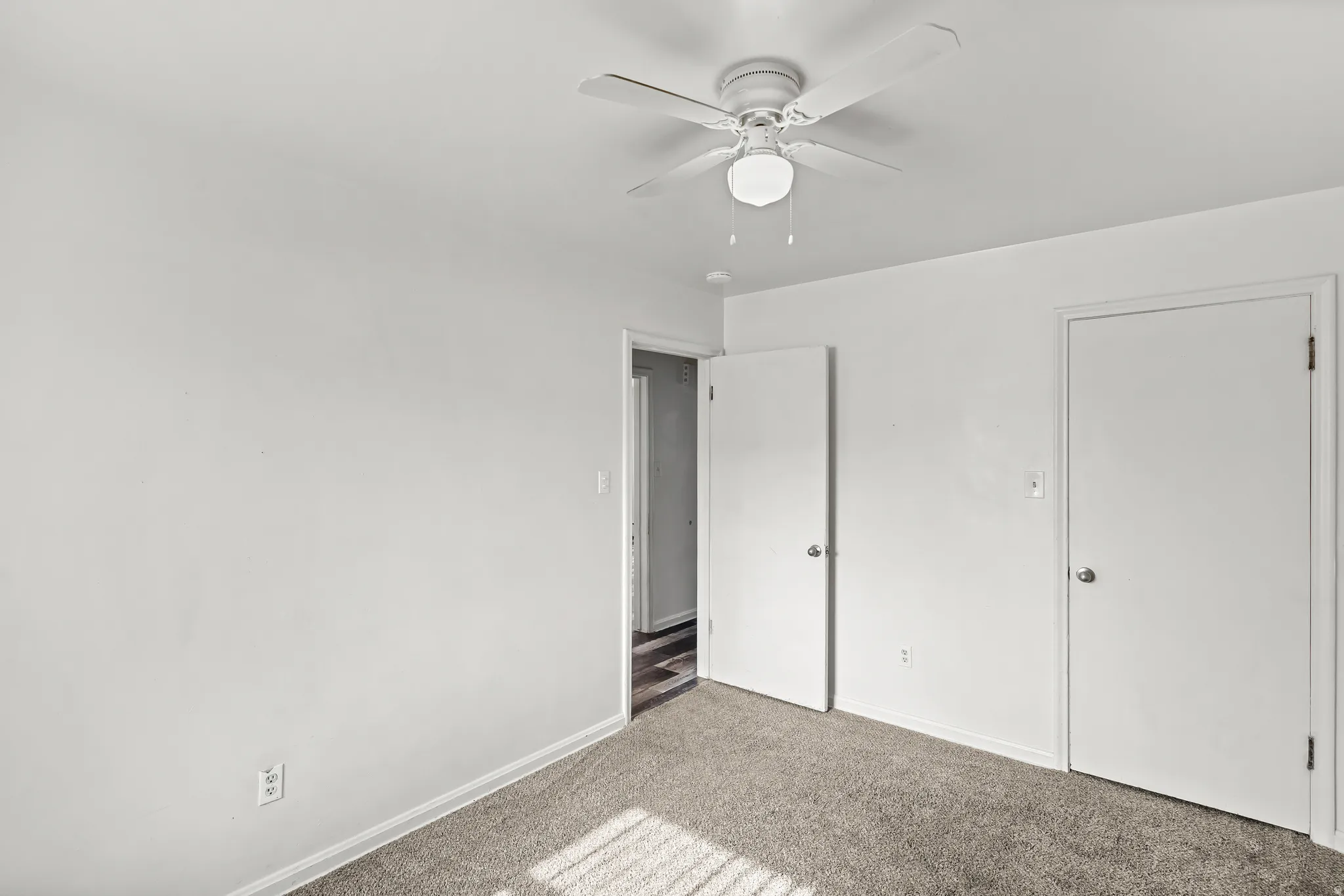 Carpeted flooring with painted walls and a ceiling fan with integrated lighting