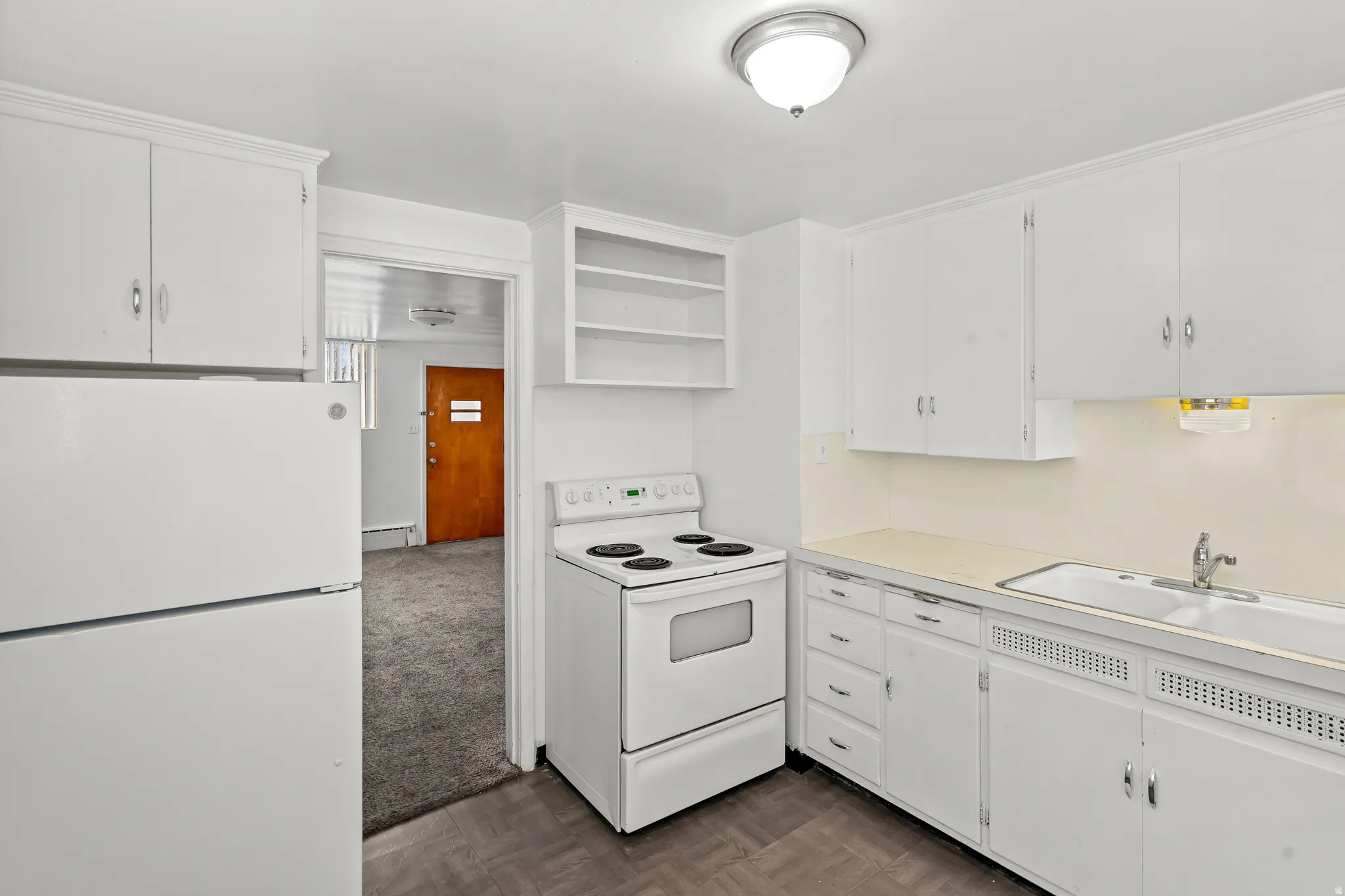 Kitchen featuring white cabinetry, a double basin sink, and a white electric range