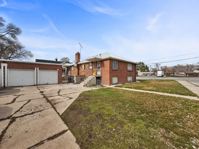 Brick exterior, dual garage doors, concrete driveway, concrete pathway, established lawn