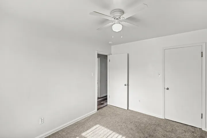 Carpeted flooring with painted walls and a ceiling fan with integrated lighting