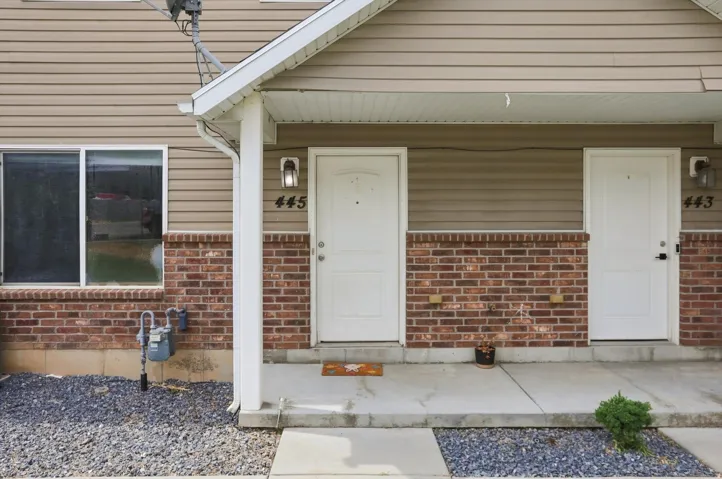 Exterior featuring horizontal siding, brick veneer, white entry doors, and covered porch