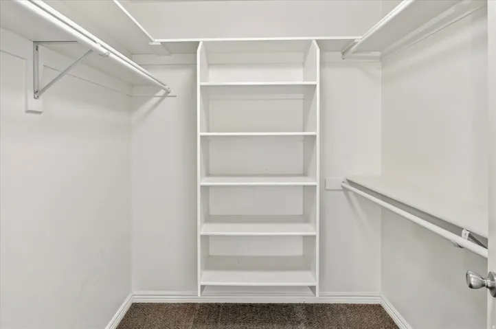 Built-in shelving unit, multiple hanging rods, and integrated upper shelving units