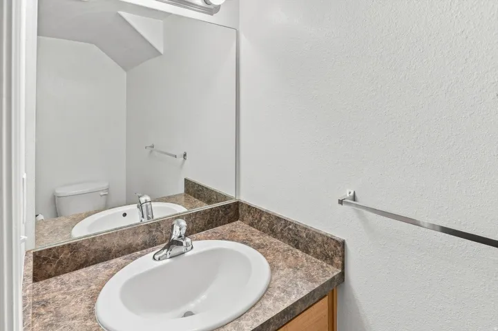 Vanity with an integrated sink, patterned countertop, and chrome faucet