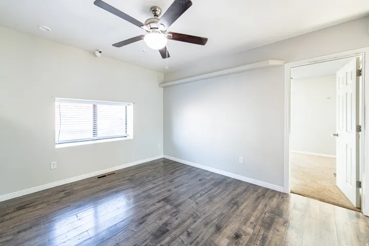 Wood-finish flooring, ceiling fan with integrated lighting, recessed lighting, horizontal blinds, and a white interior door