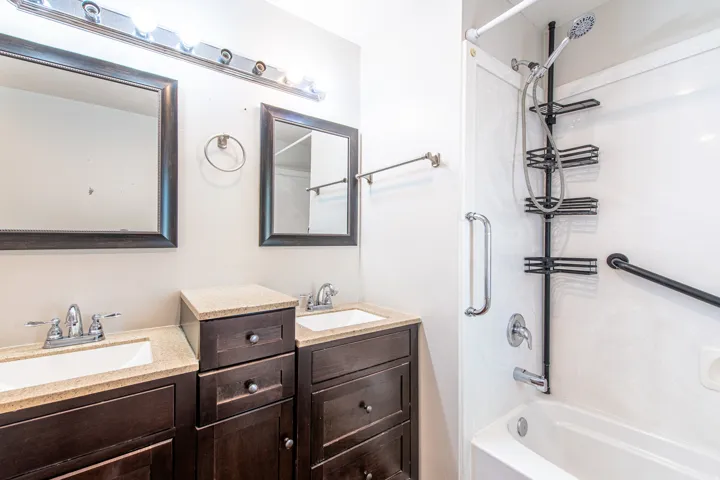 Dual vanity with dark wood-finish cabinetry and light-toned countertops