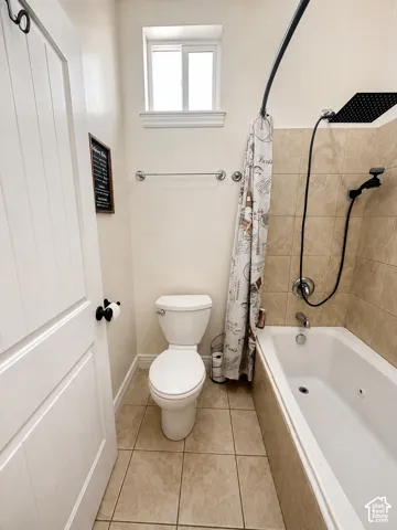 Floor tile, wall-mounted towel bar, and a window with white trim
