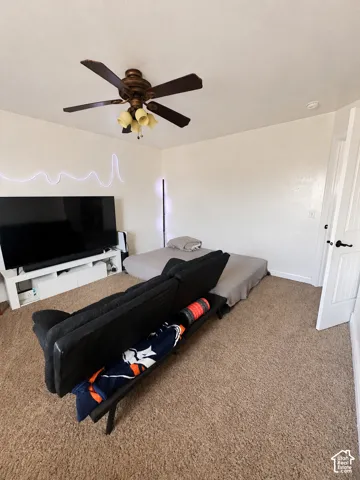 Textured wall finish, ceiling fan with integrated lighting, white interior door, and carpeted flooring