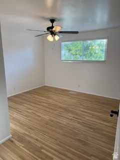 Recessed lighting, wood-finish flooring, and a ceiling fan with integrated lighting