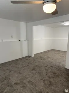 Carpeted flooring, ceiling fan with integrated lighting, recessed wall niche, and white painted walls