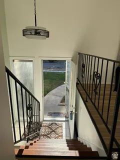 Staircase with wood-finish treads and risers, featuring a black wrought iron railing