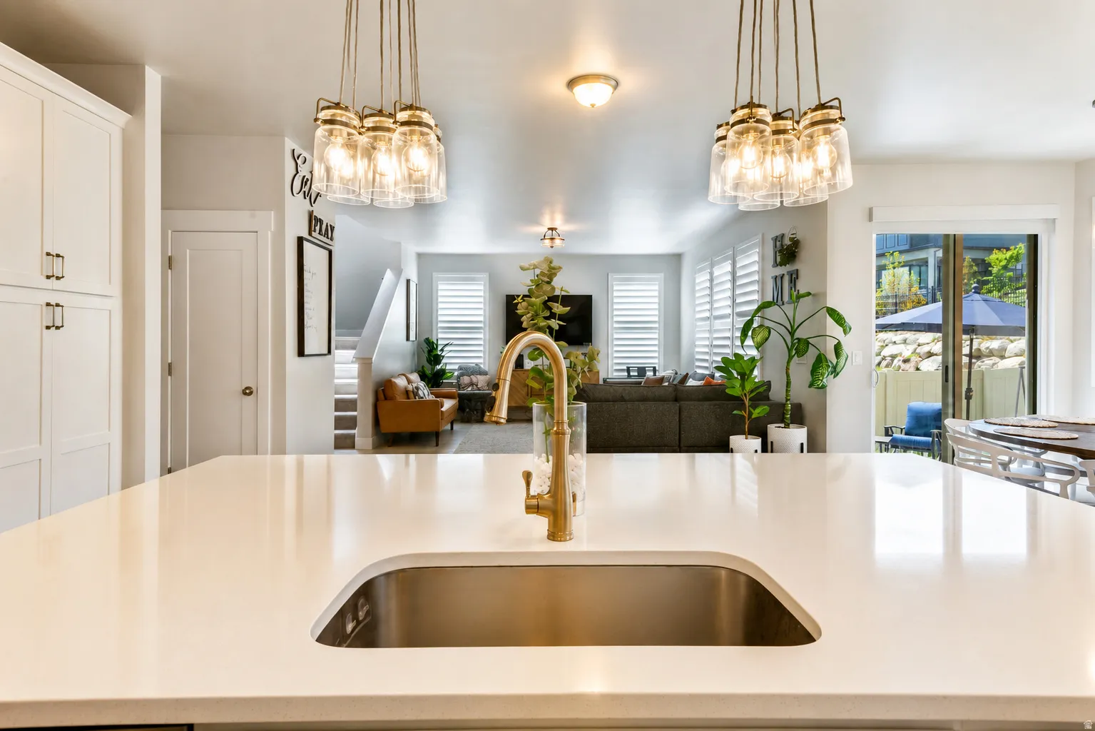 Quartz countertop island with an undermount stainless steel sink and a gold-tone faucet