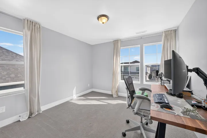 Carpeted room with multiple windows, light gray walls, and a flush-mount ceiling fixture