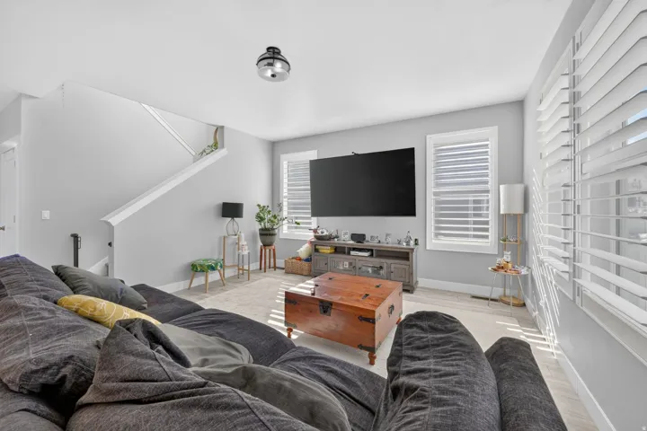 Recessed lighting, wood-finish flooring, staircase with white railing, and white plantation shutters