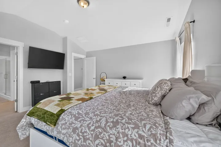 Built-in wall-mounted television, recessed lighting, and soft gray wall tones