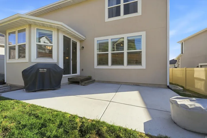 Expansive concrete patio with direct access to a sliding glass door and a bay window