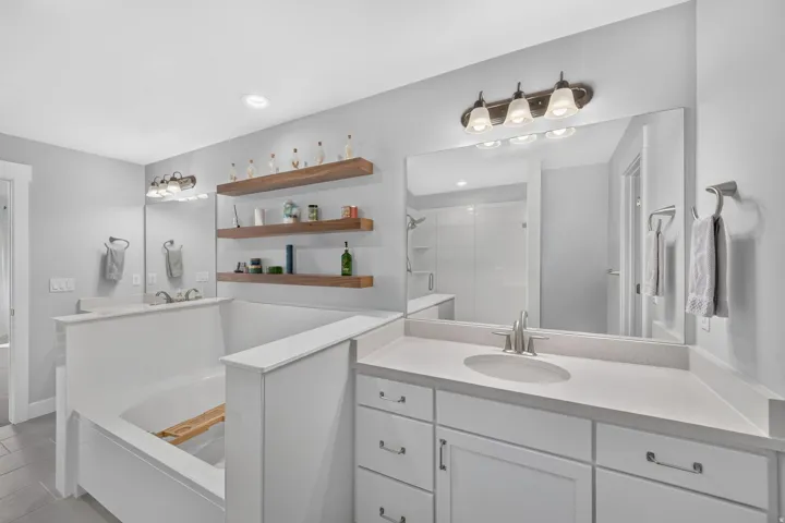 Dual vanity with undermount sinks, white cabinetry, and light-toned countertops