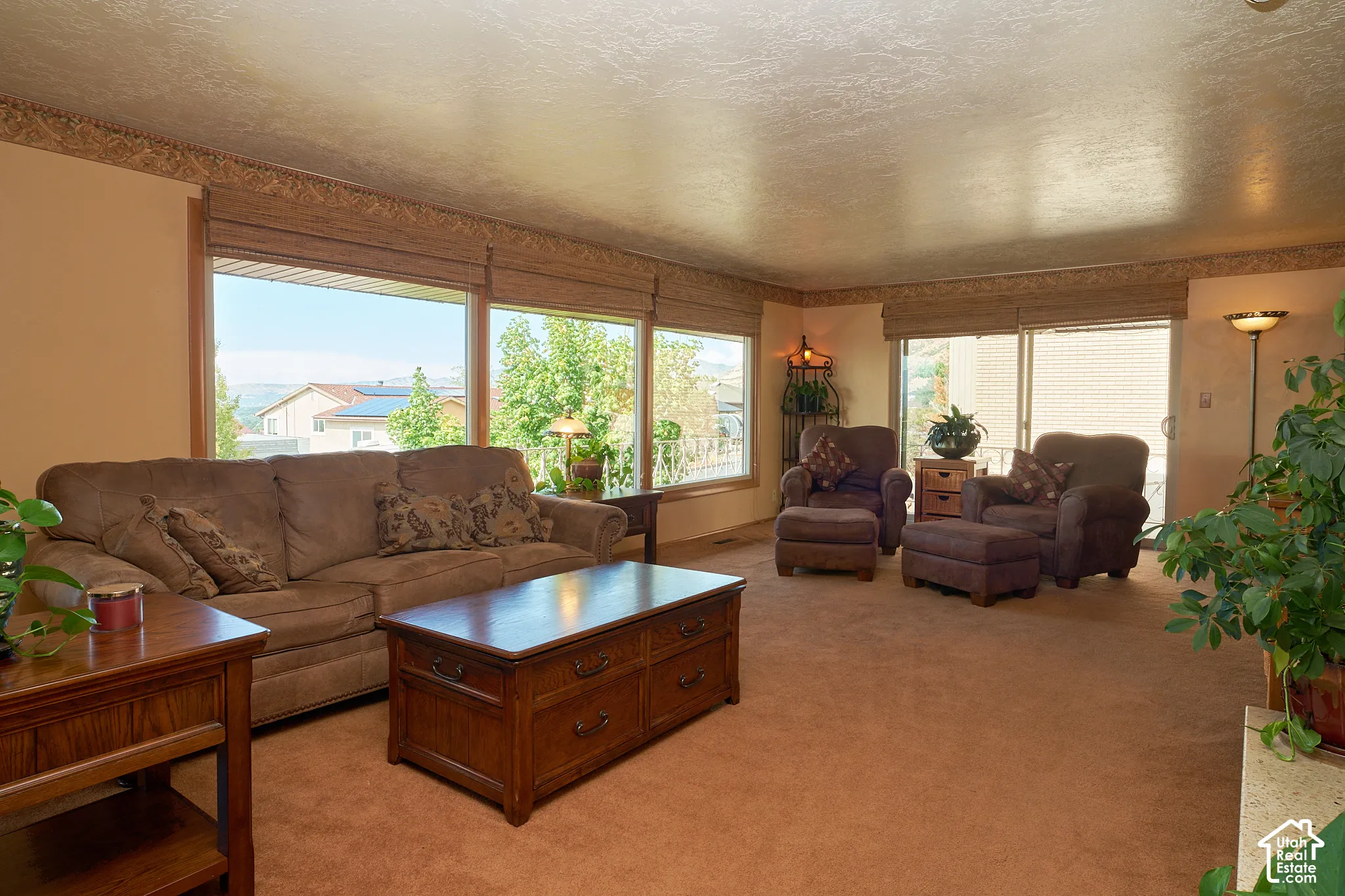 Wall-to-wall carpeting in a neutral tone, expansive windows, and a sliding glass door