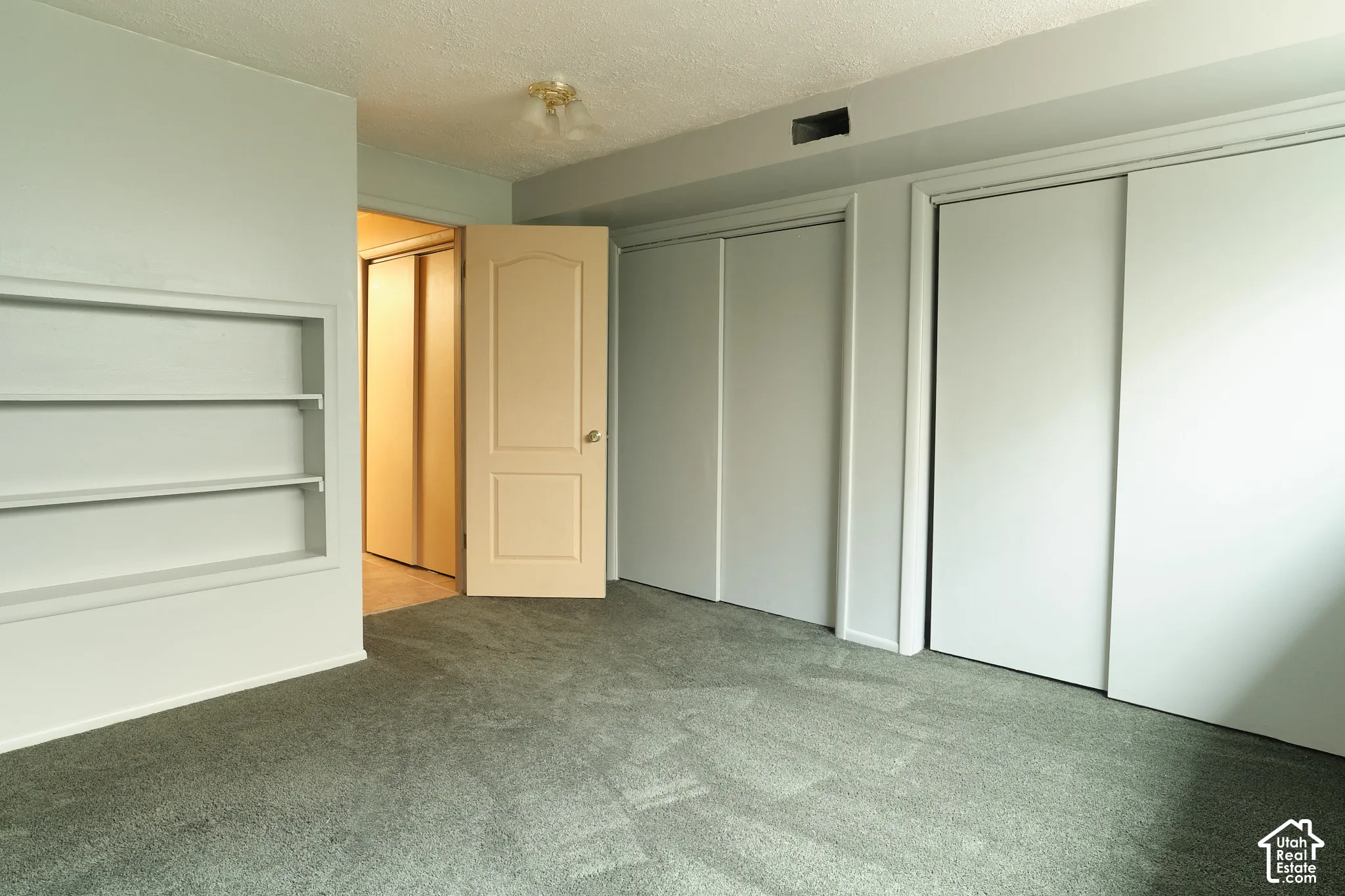 Built-in shelving, plush carpeting, light-colored walls.