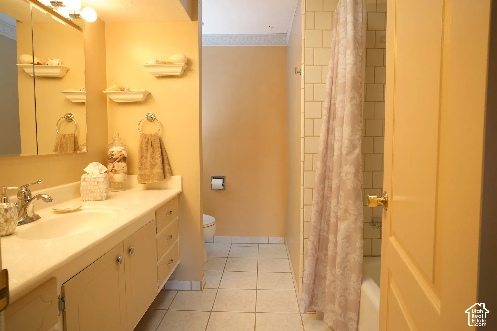 Bathroom featuring a single vanity with storage cabinetry, integrated sink, and wall-mounted mirror with overhead lighting