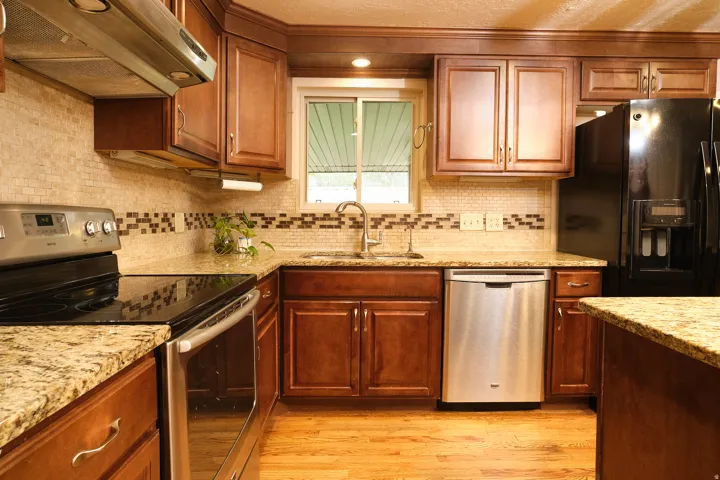 Hardwood flooring and granite countertops, stainless steel appliances, and a tiled backsplash