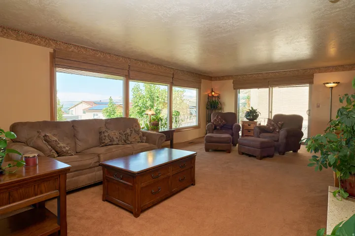 Wall-to-wall carpeting in a neutral tone, expansive windows, and a sliding glass door