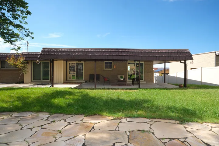 Expansive backyard featuring a flagstone patio and a covered concrete patio