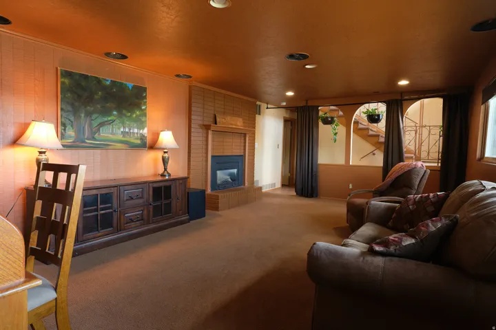 Recessed lighting and a brick fireplace with a hearth. Black out curtains  transforms this room into a theatre room.