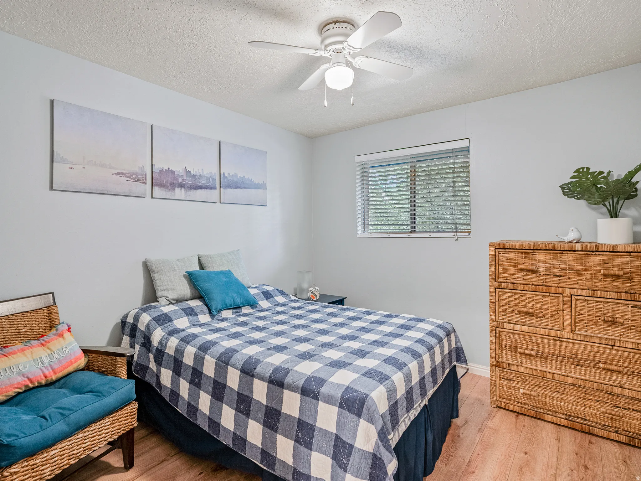 Wood-finish flooring with light-toned walls and a ceiling fan