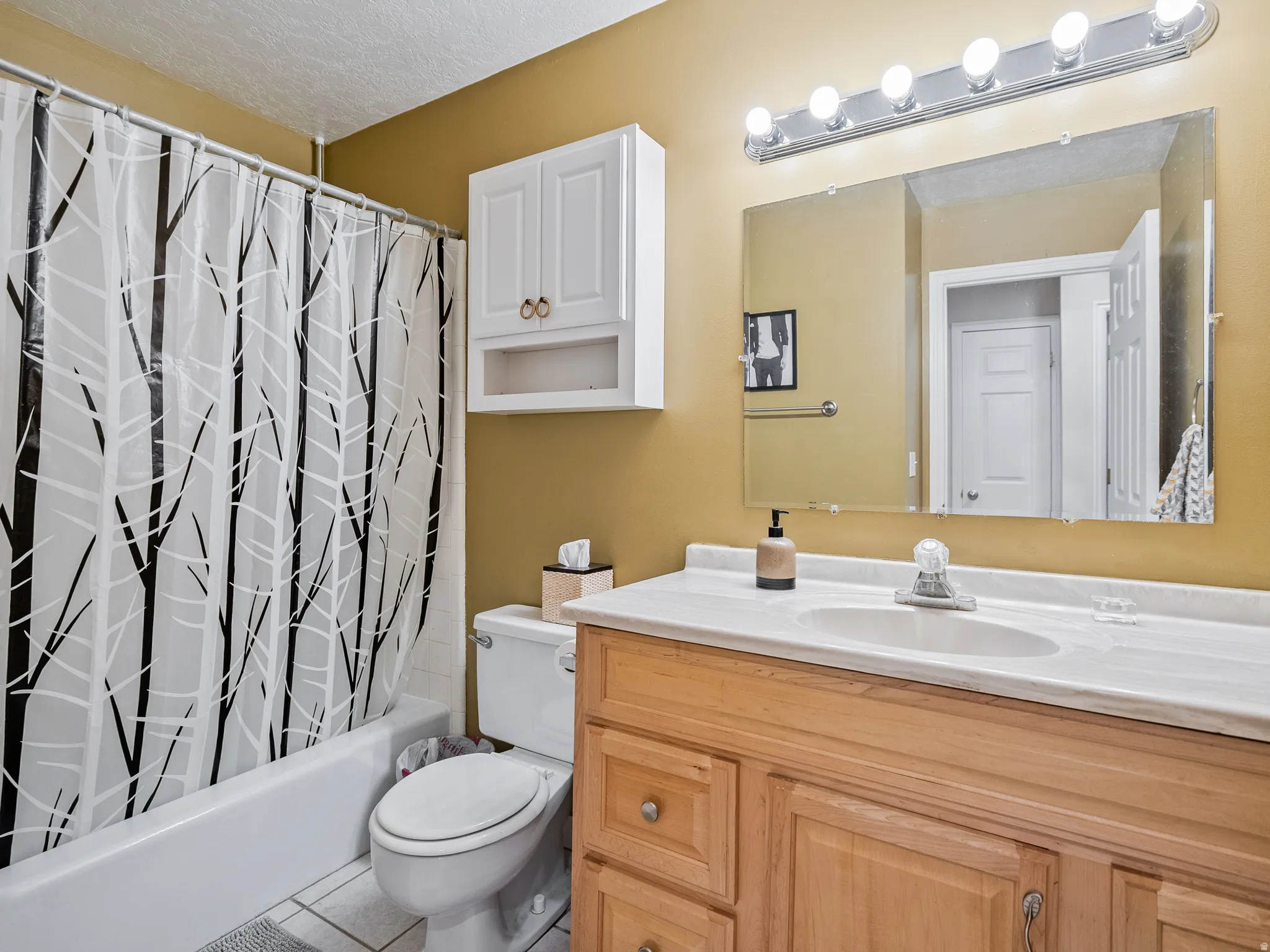 Bathroom featuring a vanity with a light-colored countertop, a built-in sink, and wood-finish cabinetry