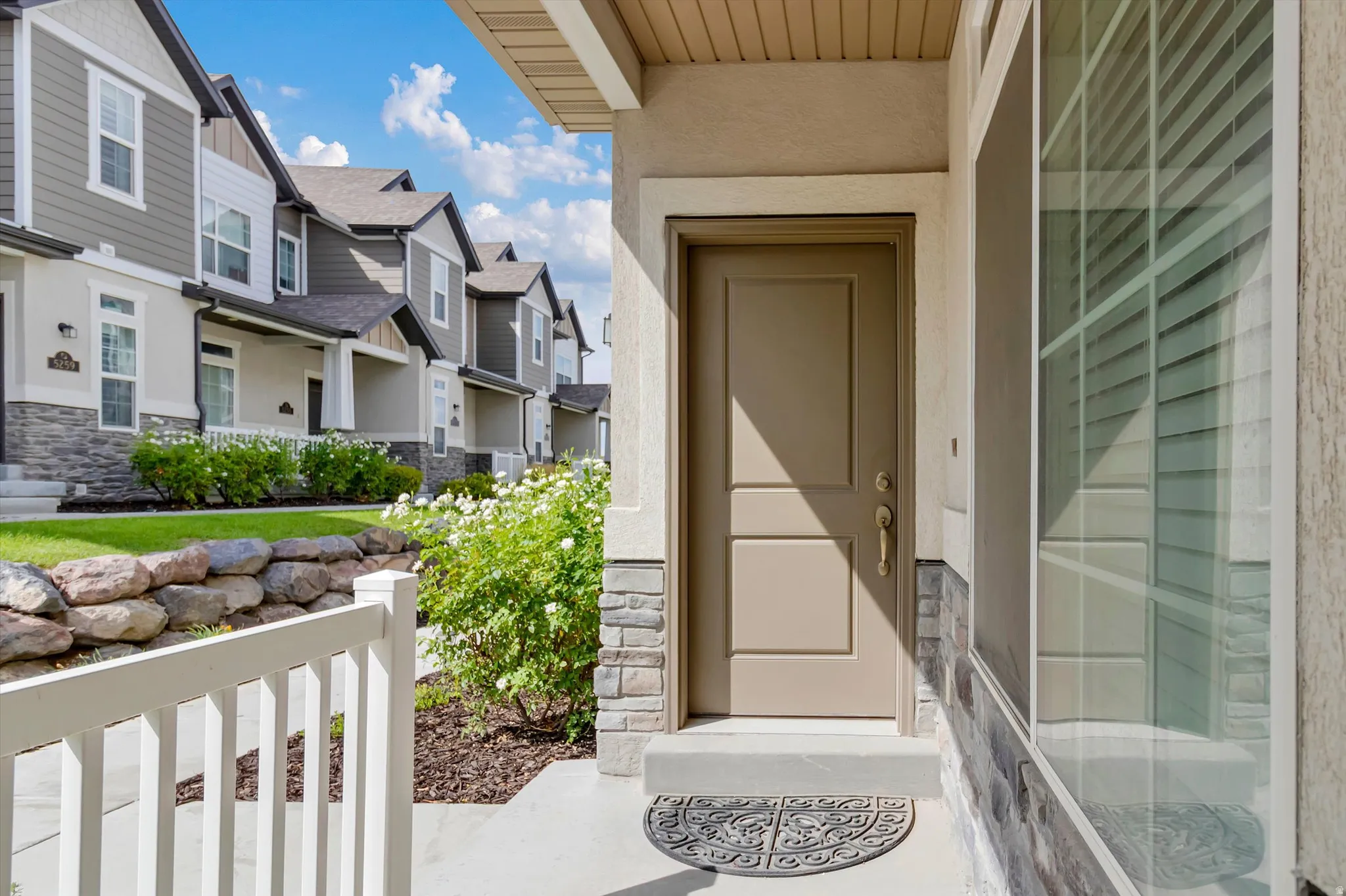 Entry features a solid panel door, sidelight, and stone veneer accents