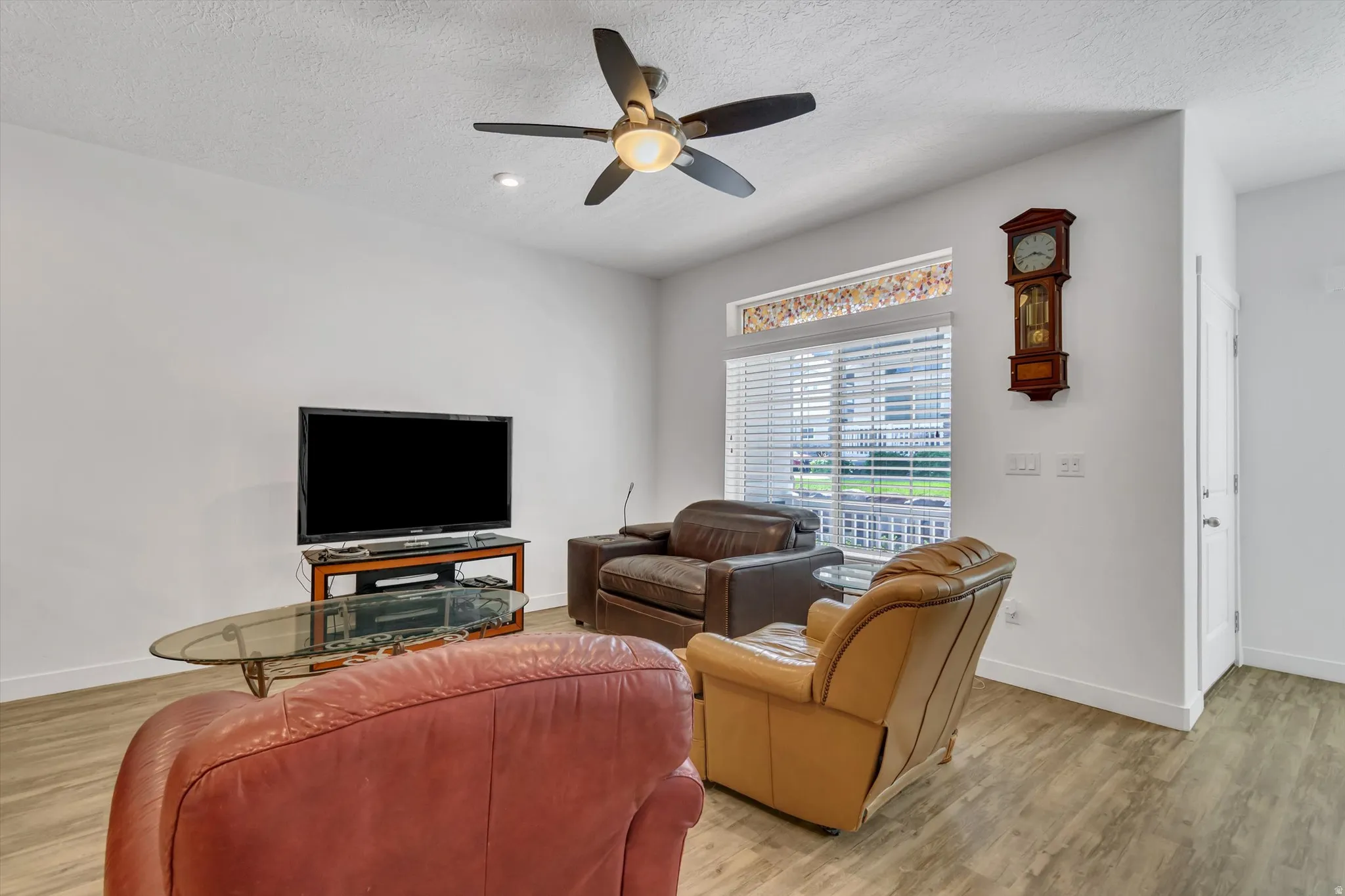 Wood-finish flooring with a ceiling fan, recessed lighting, and white baseboards
