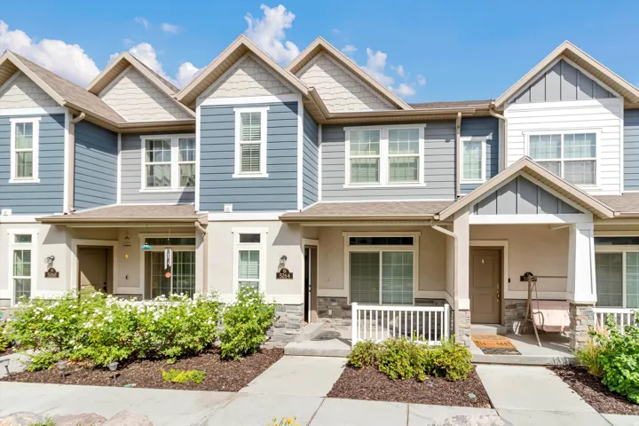 Contemporary townhome exterior featuring multi-toned siding, stone accents, and covered entryways