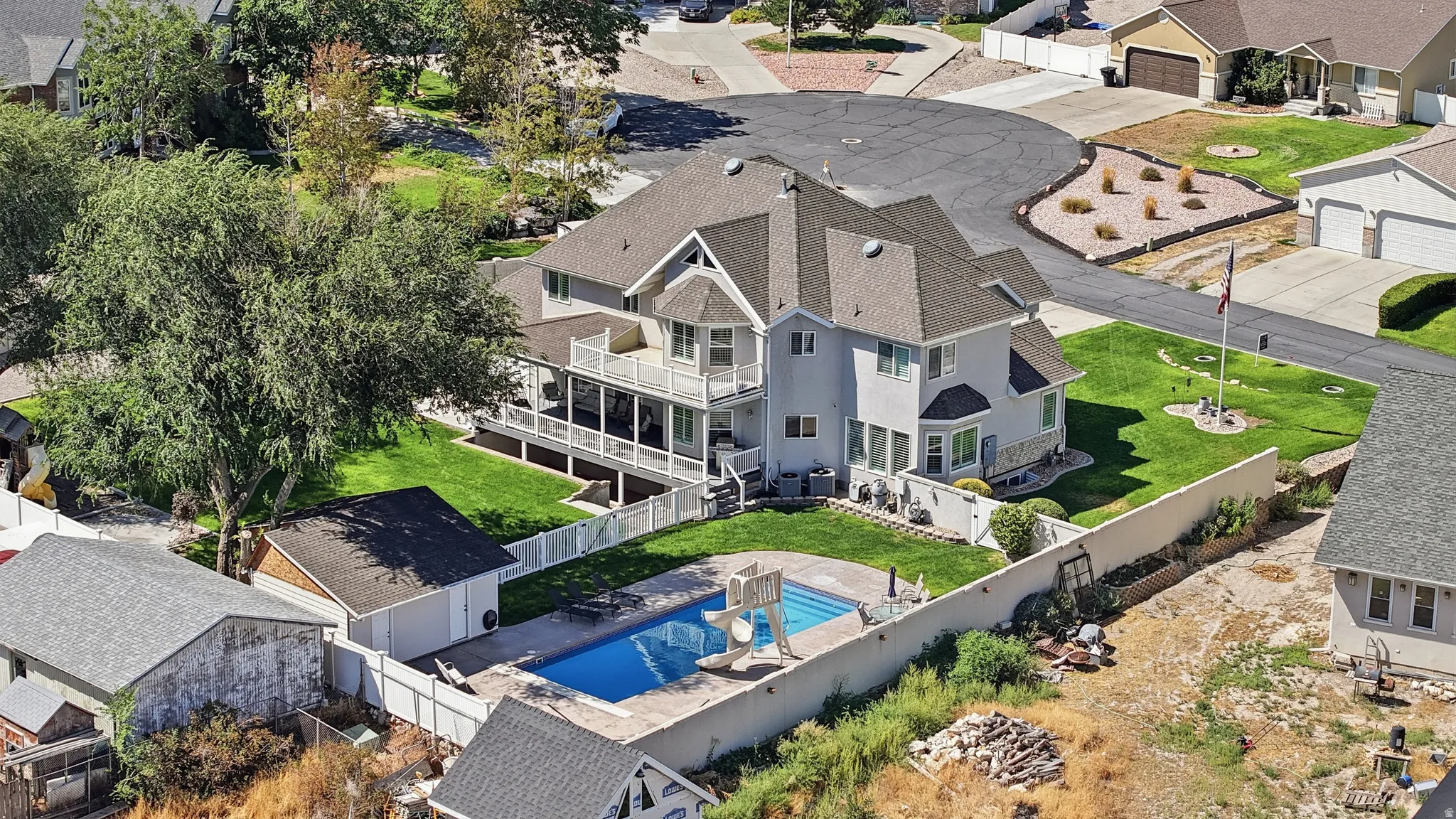 Spacious property featuring a multi-level residence with balconies, an in-ground swimming pool, a detached shed / pool house, and a manicured lawn
