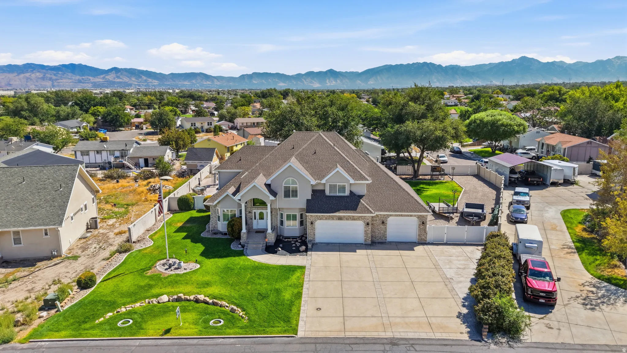 Expansive residential property featuring a large two-story house with a prominent entry, attached multi-car garage, and a broad paved driveway