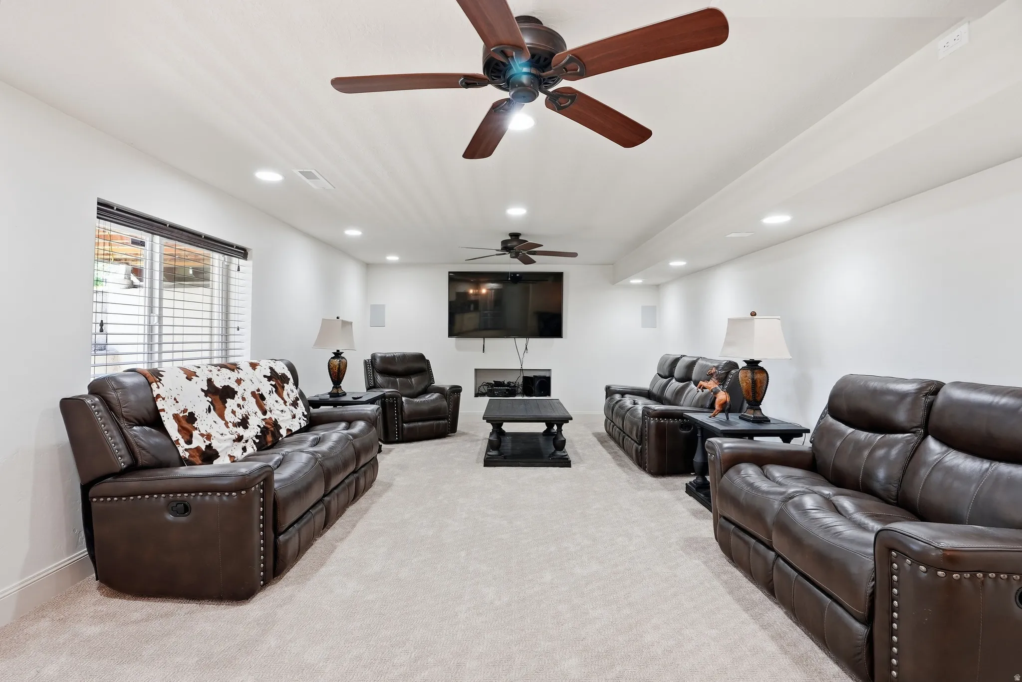 Recessed lighting, wood-finish ceiling fans, and a window with blinds
