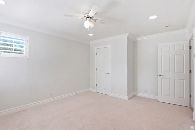 Recessed lighting, crown molding, ceiling fan, neutral wall tones, and carpet flooring