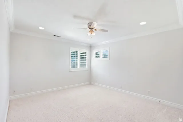 Recessed ceiling lighting, ceiling fan, crown molding, white plantation shutters, and light-toned carpeting