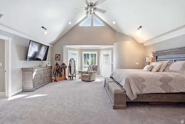 Master Suite: Vaulted ceiling with a ceiling fan and recessed lighting, bay window with plantation shutters, light gray carpet, and white trim, private balcony.