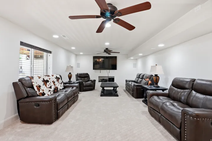 Recessed lighting, wood-finish ceiling fans, and a window with blinds