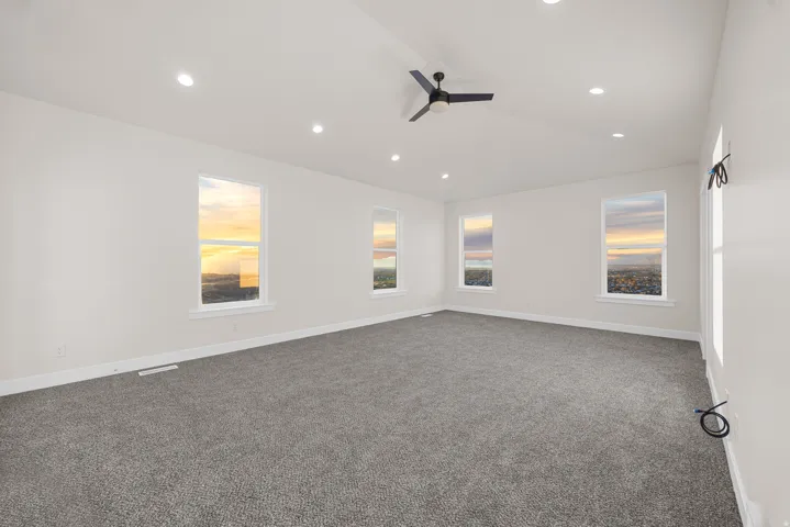 Vaulted ceiling with recessed lighting and a ceiling fan