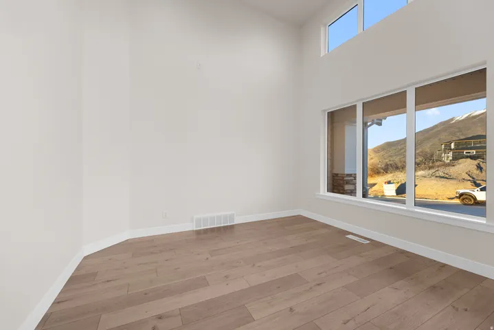 High ceilings with transom windows, expansive lower windows, and wood-finish flooring