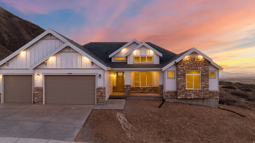 Modern exterior featuring vertical and horizontal siding, stone accents, and a dual garage