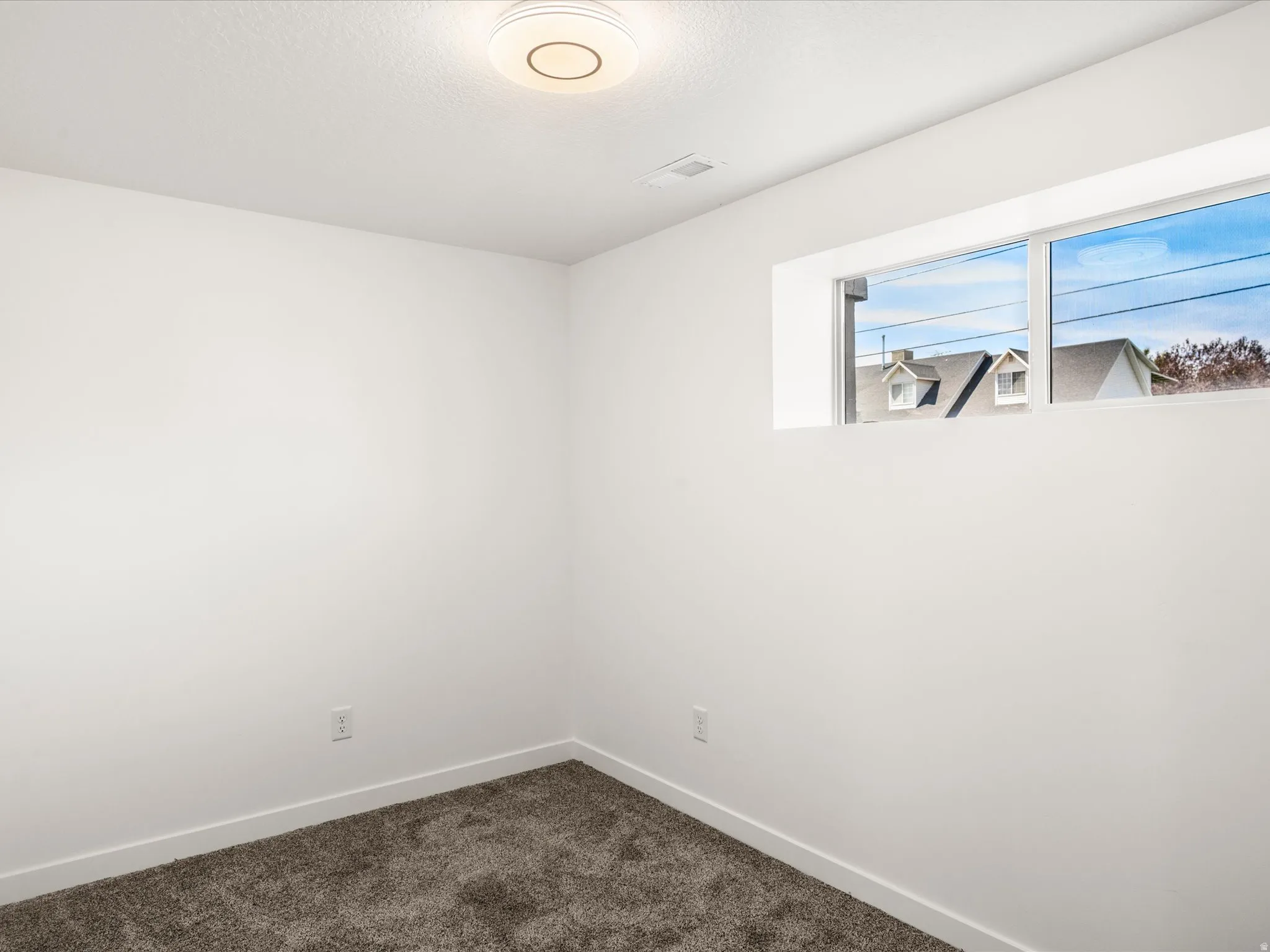 Bedroom #4 Downstairs. Neutral wall paint, plush carpet flooring, recessed window, and flush-mount ceiling light fixture