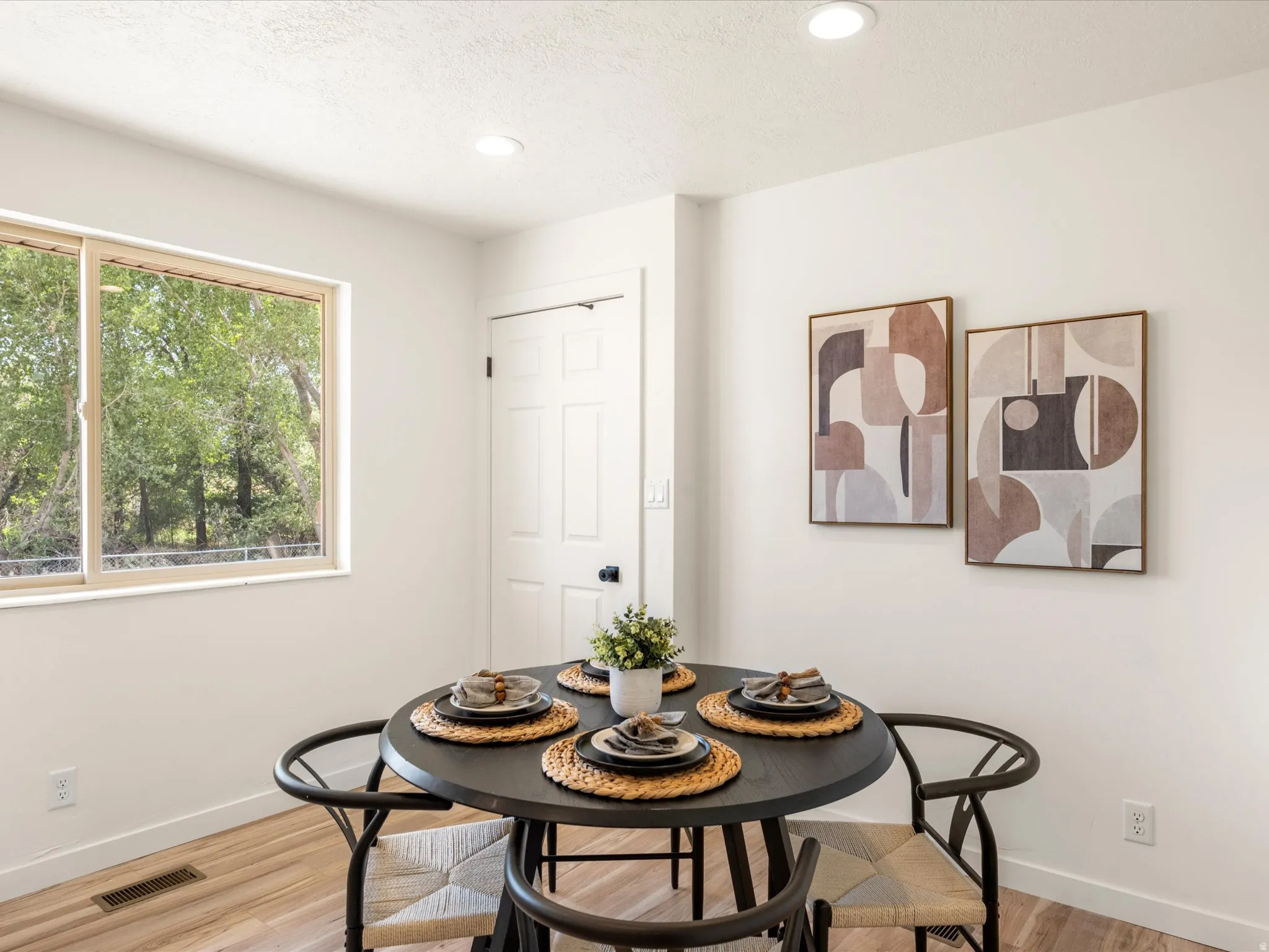 Recessed lighting illuminates the neutral wall tones and wood-finish flooring