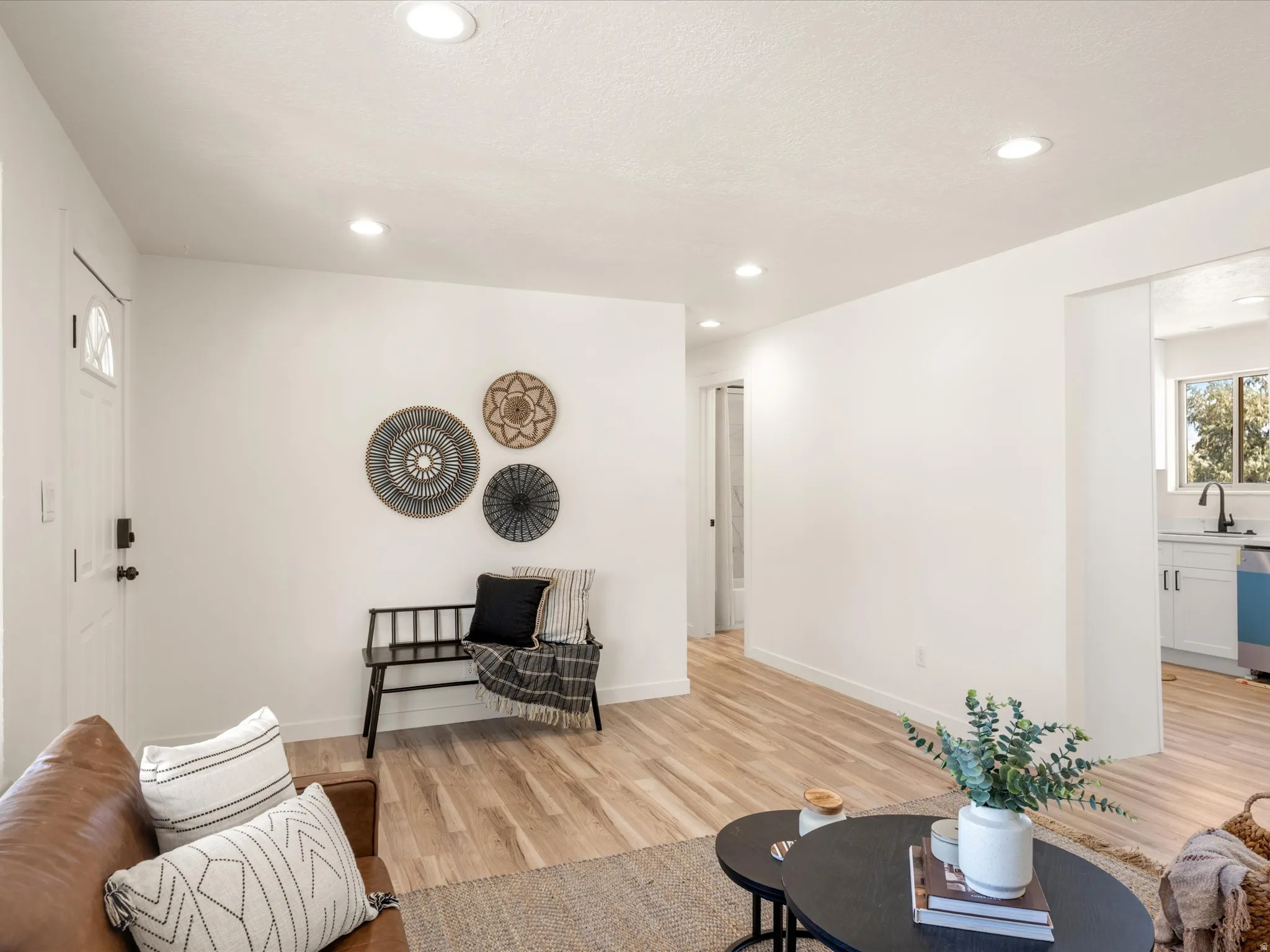 Light-toned wood-finish flooring, recessed ceiling lighting, and crisp white walls throughout